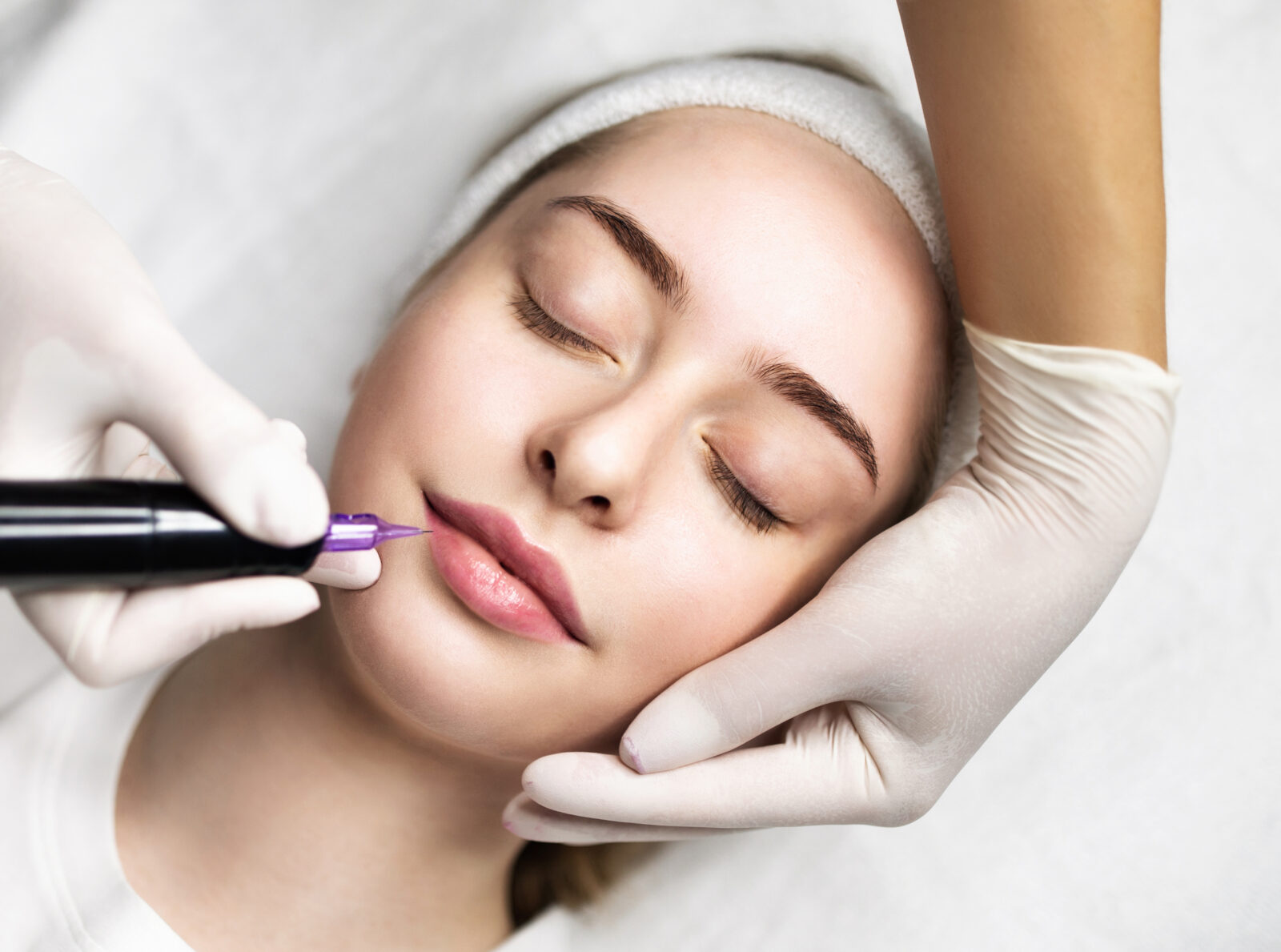 Beautician Doing Permanent Makeup For Lips Of Young Attractive Woman